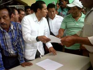 Erick Lagos, secretario de gobierno, entrega la minuta a los ejidatarios.