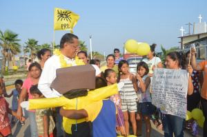Fue recibido con un collar de flores amarillas, un muñeco de papel y cartón elaborado por niños de la Colonia y un mensaje de gratitud hacia su persona.
