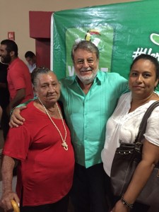 Tony Macías con su equipo de promotoras, con la camisa verde bien puesta.