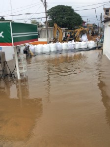 Una gasolinera de PEMEX se vino a pique, anegada por las inundaciones. Ponen un tapón con sacos de arenas.