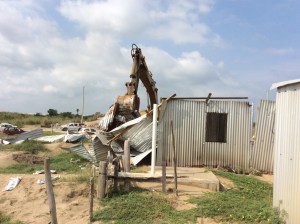 La maquinaria pesada de la Fiscalía destruye las viviendas asentadas de los invasores.