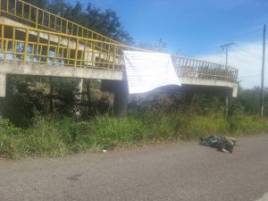 Un ejecutado, en Pueblo Viejo, bajo una narcomanta.