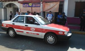 La Policía Estatal resguarda el taxi donde ocurrió el robo.