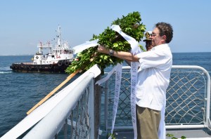 El director de la APICOAT, con una ofrenda floral al mar.