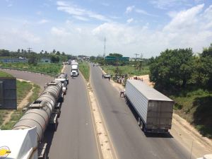 Larga hilera de vehículos y transportistas, varados.
