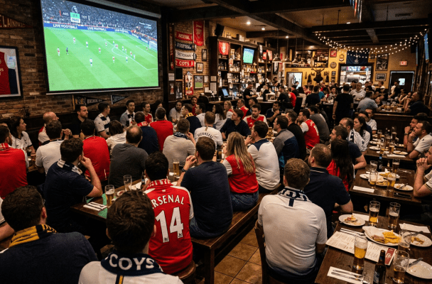 Crowd watching Arsenal versus Tottenham football match in a sports bar