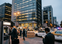 BID building with street vendors, taxis, and pedestrians at dusk